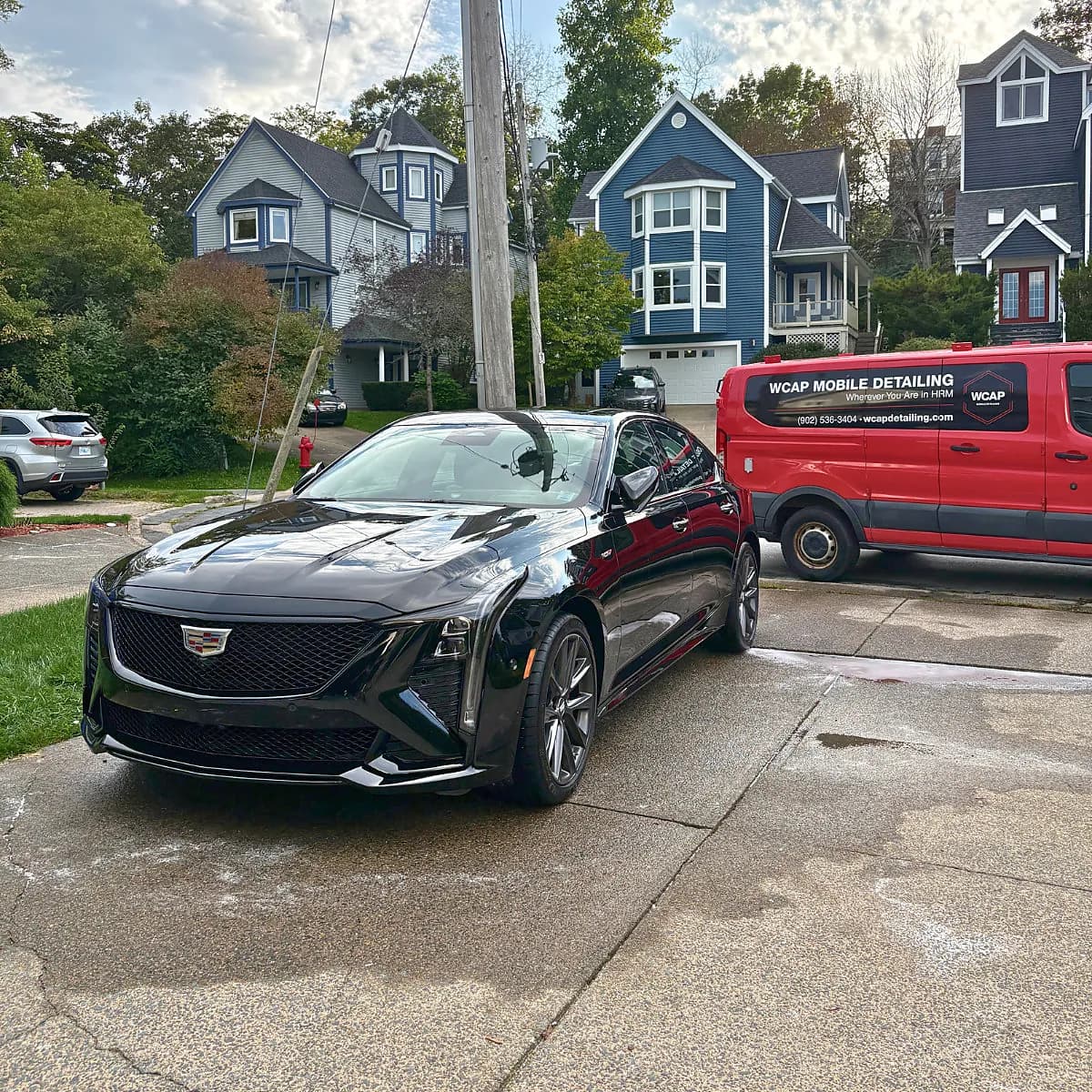 Black Cadillac after WCAP Detailing mobile service with the WCAP Detailing van on site in HRM